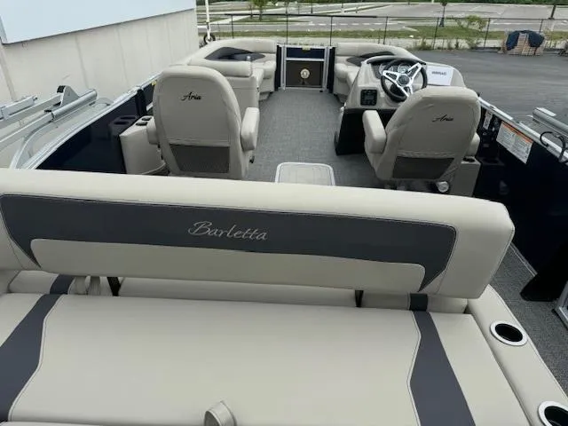 Slide: The Image of 2024 Barletta Aria 24UC pontoon boat interior with beige seating and steering console. - 6
