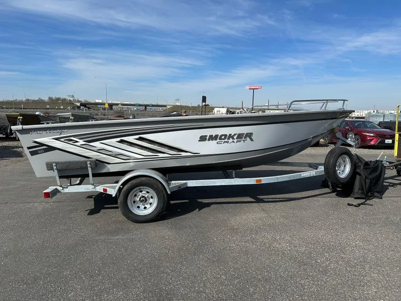 The Image of 2024 Smoker Craft Pro Lodge 160 boat on a trailer in a parking lot. - 0