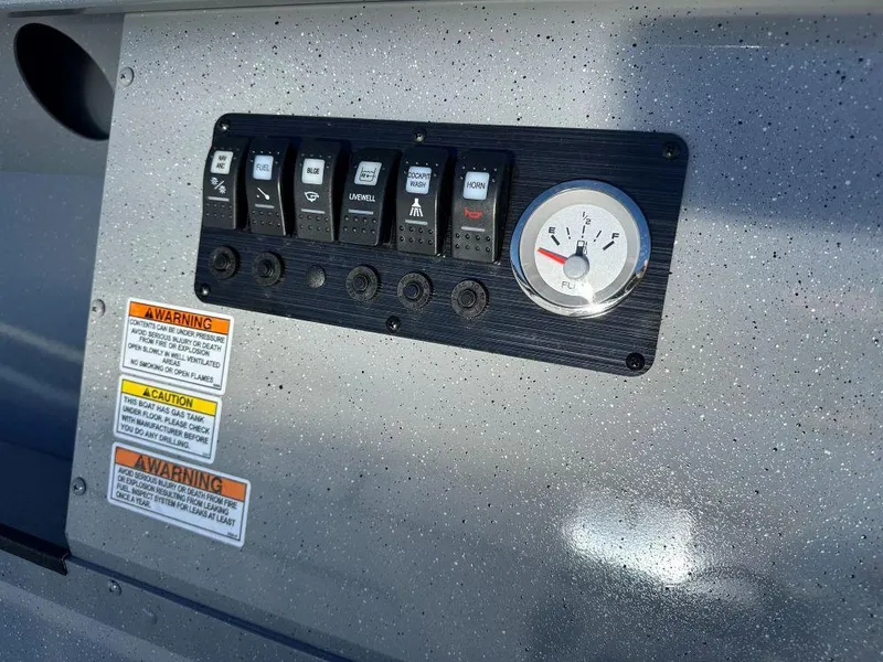 Slide: The Image of Control panel of 2024 Smoker Craft Pro Sportsman 2072 boat with warning labels. - 4