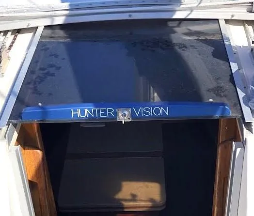 Slide: The Image of 1990 Hunter Vision 32 yacht entrance with blue trim and sliding hatch. - 10