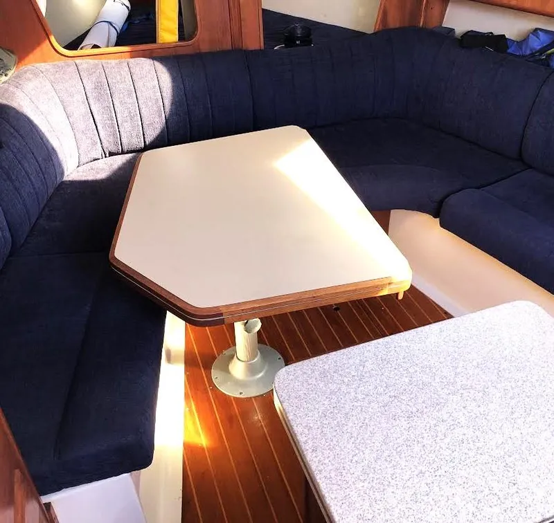 Slide: The Image of Cozy interior of 1990 Hunter Vision 32 sailboat with blue seating and wooden table. - 12