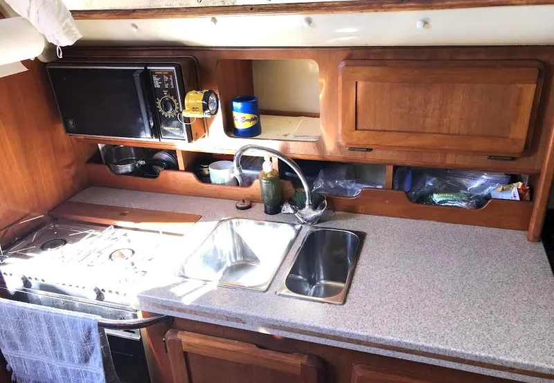 Slide: The Image of 1990 Hunter Vision 32 yacht kitchen with sink, stove, and microwave. - 13