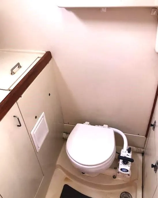 Slide: The Image of 1990 Hunter Vision 32 boat bathroom with compact toilet and storage cabinets. - 18