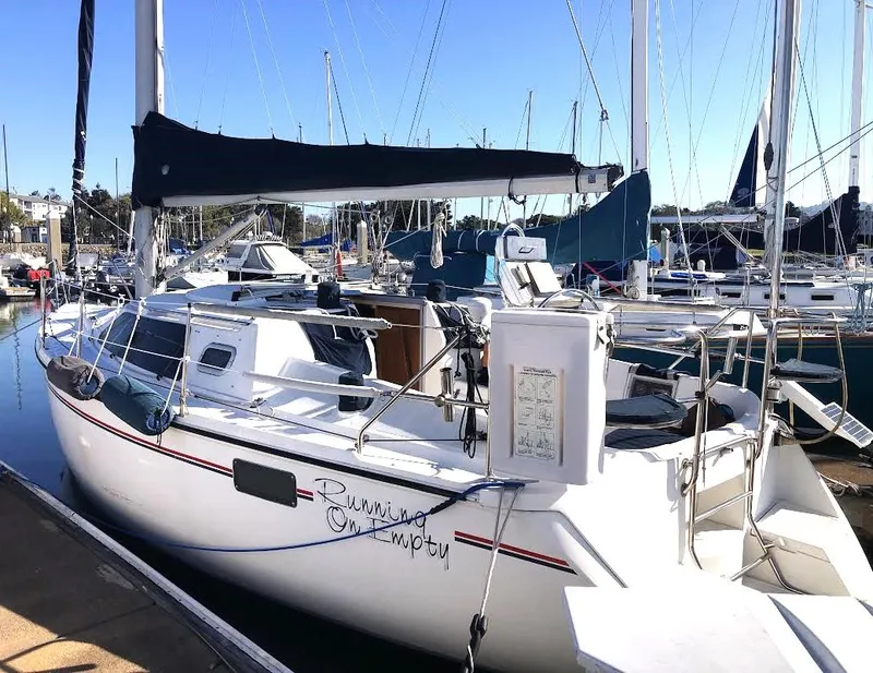 Slide: The Image of Hunter Vision 32 sailboat, 1990 model, docked in a marina under clear blue skies. - 2