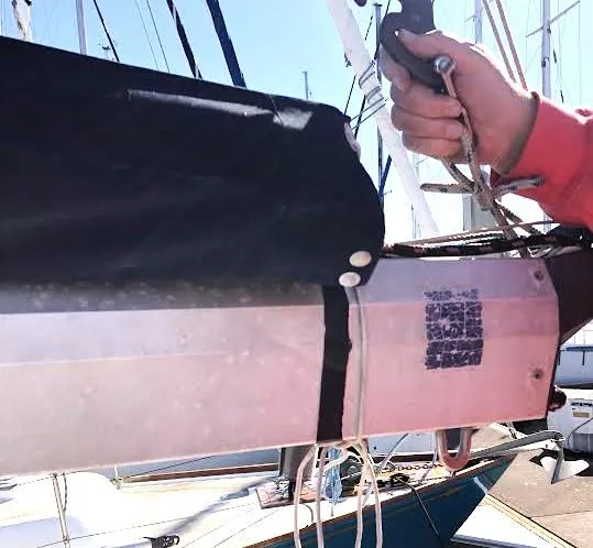 Slide: The Image of Hand adjusting sail rigging on 1990 Hunter Vision 32 sailboat. - 29