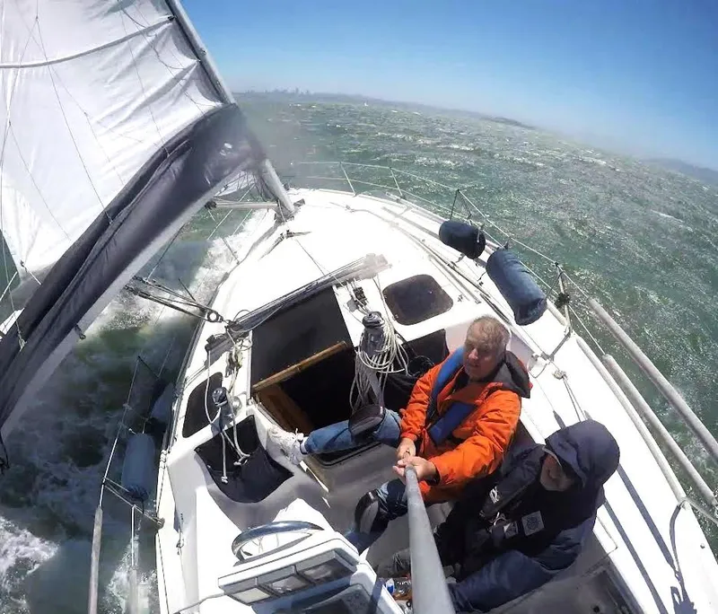 Slide: The Image of Two people sailing on a 1990 Hunter Vision 32 yacht in choppy waters. - 8