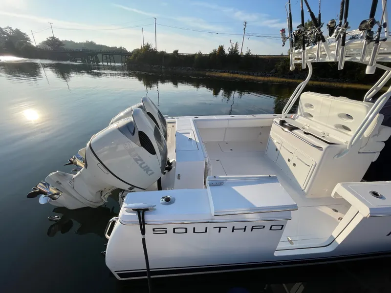 Slide: The Image of 2018 Southport 33 FE boat with Suzuki outboard engines docked on calm water. - 10