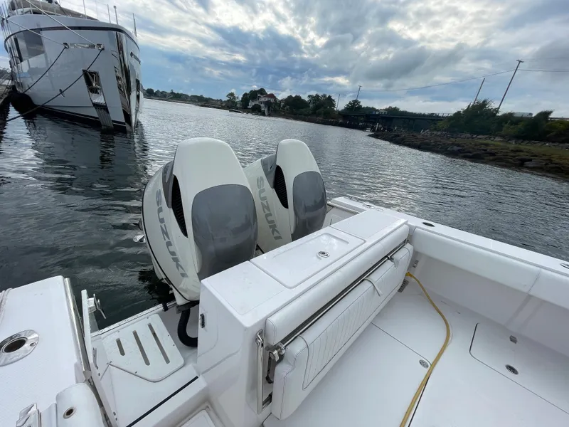 Slide: The Image of 2018 Southport 33 FE boat with twin outboard engines docked on calm water. - 12