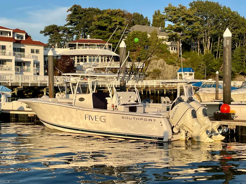 Slide: The Image of 2018 Southport 33 FE boat docked at a marina with scenic waterfront homes. - 2