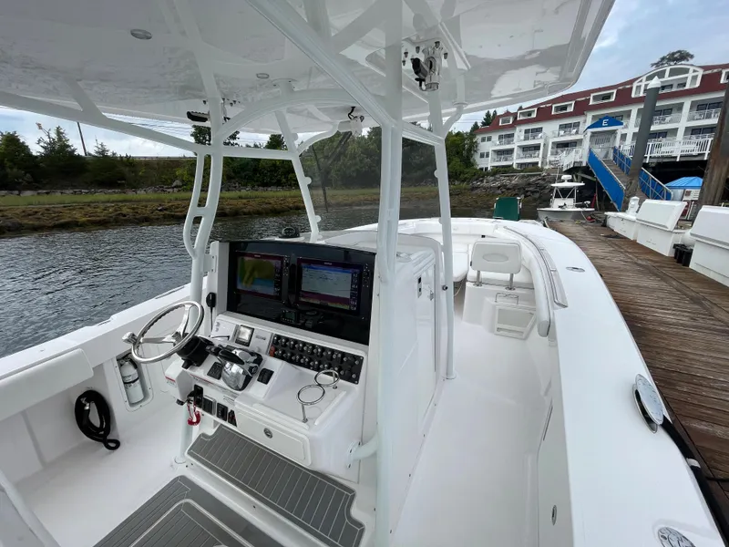 Slide: The Image of 2018 Southport 33 FE boat docked, featuring a modern helm with dual screens. - 22