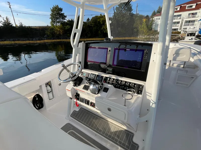 Slide: The Image of 2018 Southport 33 FE boat cockpit with dual navigation screens and steering wheel. - 26