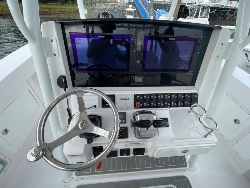 Slide: The Image of 2018 Southport 33 FE boat dashboard with dual Simrad displays and steering wheel. - 27