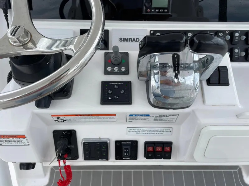 Slide: The Image of 2018 Southport 33 FE boat control panel with steering wheel and throttle. - 32