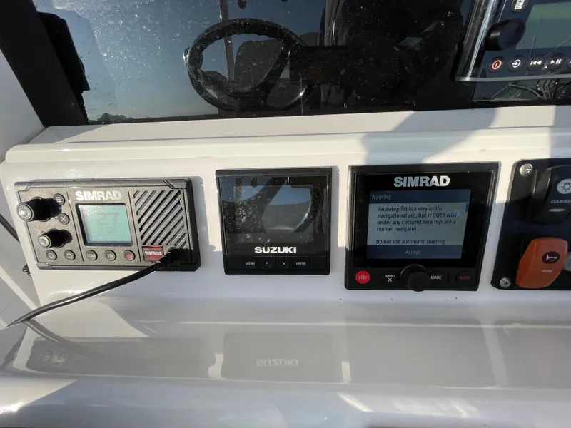 Slide: The Image of Control panel of a 2018 Southport 33 FE boat with Simrad and Suzuki displays. - 33