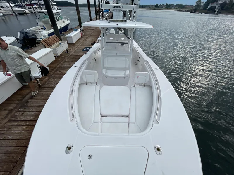 Slide: The Image of 2018 Southport 33 FE boat docked at a marina, featuring spacious seating and a sleek design. - 40
