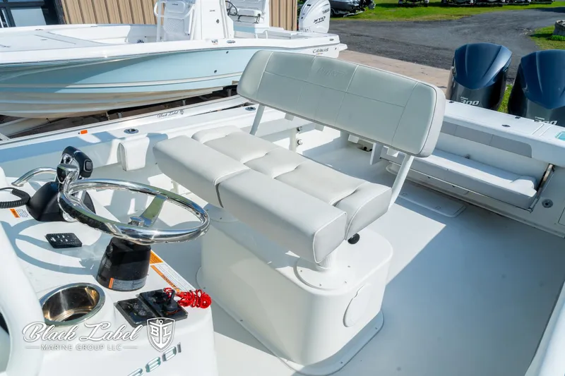 Slide: The Image of 2020 Parker 2801cc boat interior with white seating and steering wheel. - 12