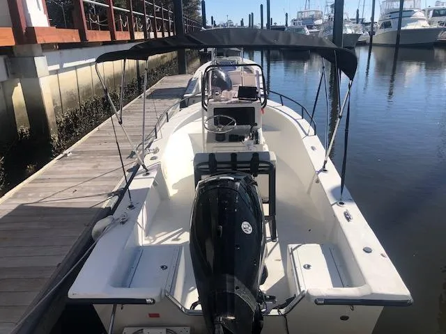Slide: The Image of 2021 May-Craft 1800 Skiff docked, featuring a central console and outboard motor. - 2