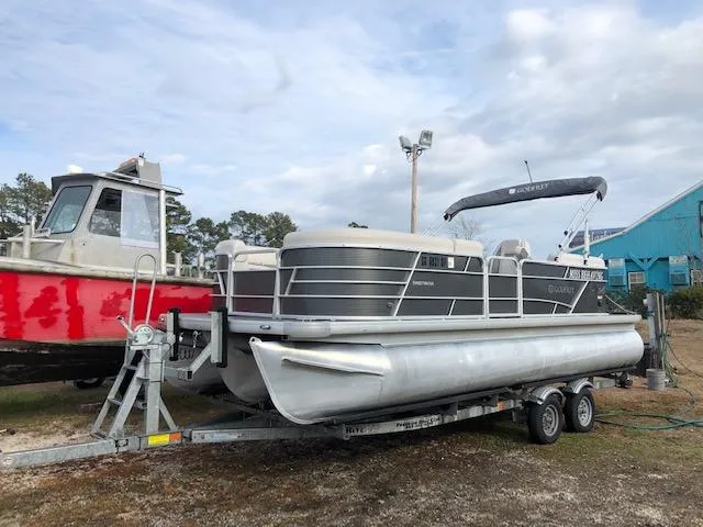 The Image of 2021 Sweetwater 2286 pontoon boat on a trailer, parked outdoors. - 1