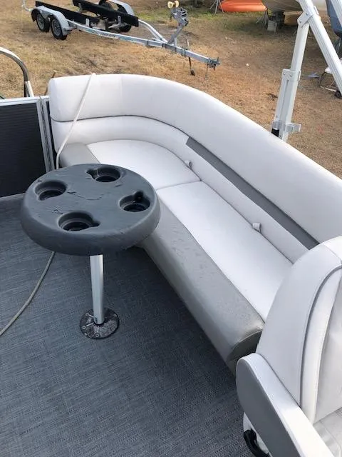 Slide: The Image of 2021 Sweetwater 2286 boat interior with white seating and cup holder table. - 10