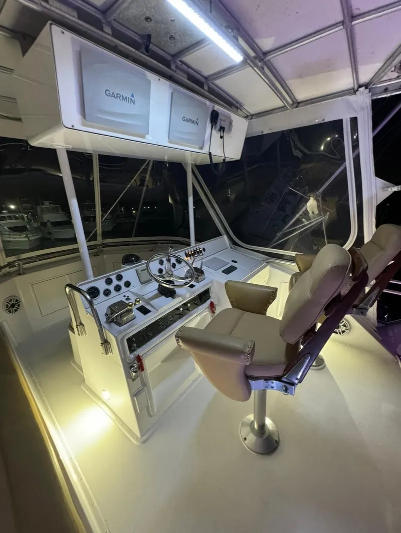 Slide: The Image of 1990 Hatteras 45 Convertible yacht helm with Garmin navigation, illuminated at night. - 14