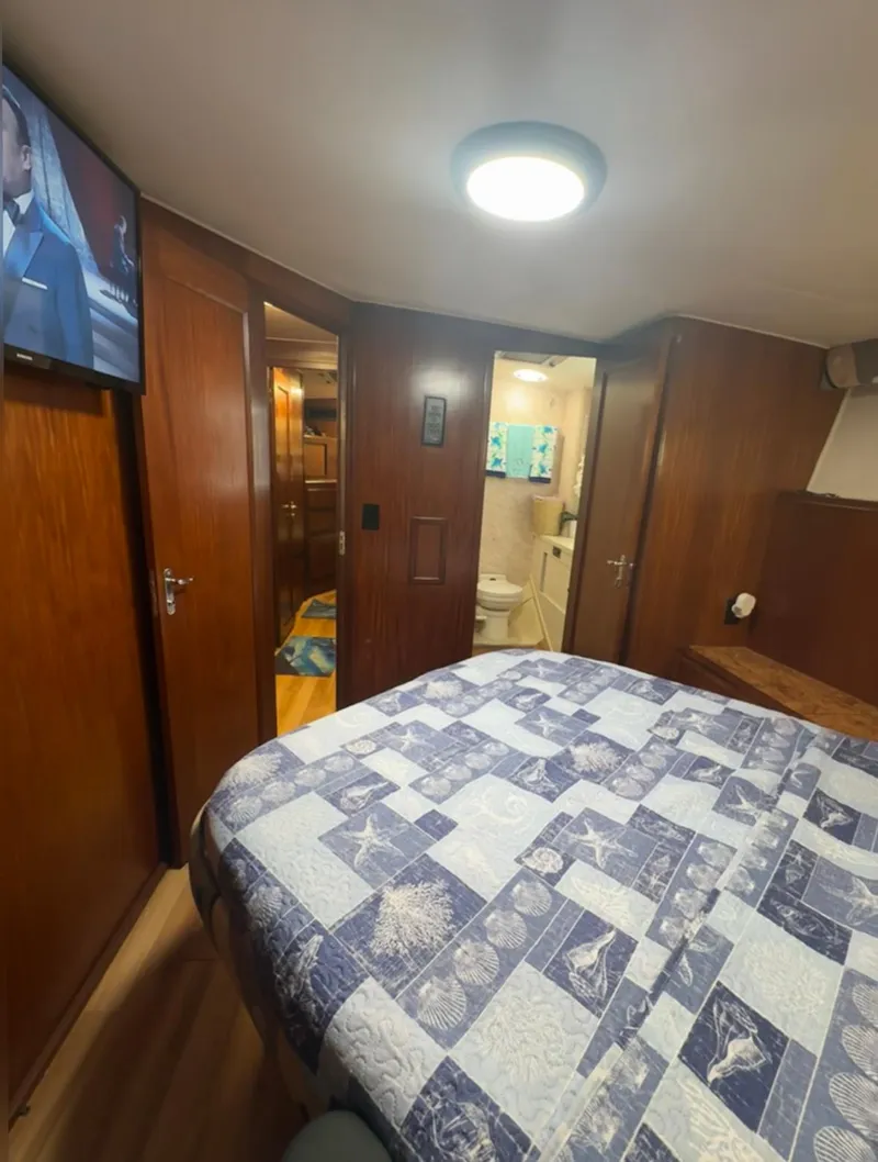 Slide: The Image of 1990 Hatteras 45 Convertible yacht bedroom with quilted bedspread and en-suite bathroom. - 19