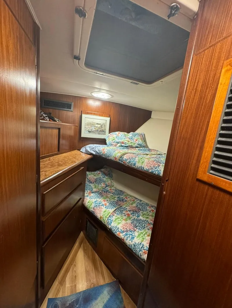 Slide: The Image of 1990 Hatteras 45 Convertible cabin with wooden interior and bunk beds. - 24
