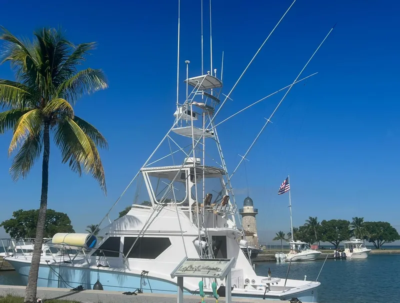 Slide: The Image of 1990 Hatteras 45 Convertible yacht docked near palm tree and lighthouse. - 7