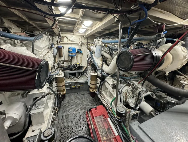 Slide: The Image of Engine room of a 1990 Hatteras 45 Convertible yacht, showcasing dual engines and mechanical components. - 9
