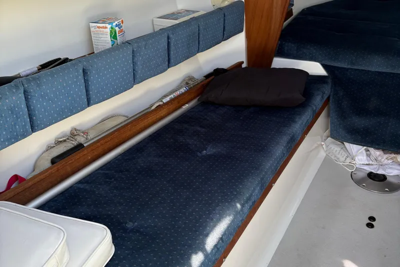 Slide: The Image of Interior of a 2002 Precision 23 sailboat with blue cushioned seating. - 13