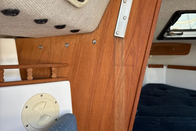Slide: The Image of Interior of a 2002 Precision 23 sailboat, featuring wood paneling and cozy cabin space. - 15