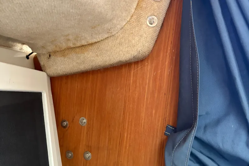 Slide: The Image of Interior view of a 2002 Precision 23 boat, featuring wood paneling and fabric details. - 19