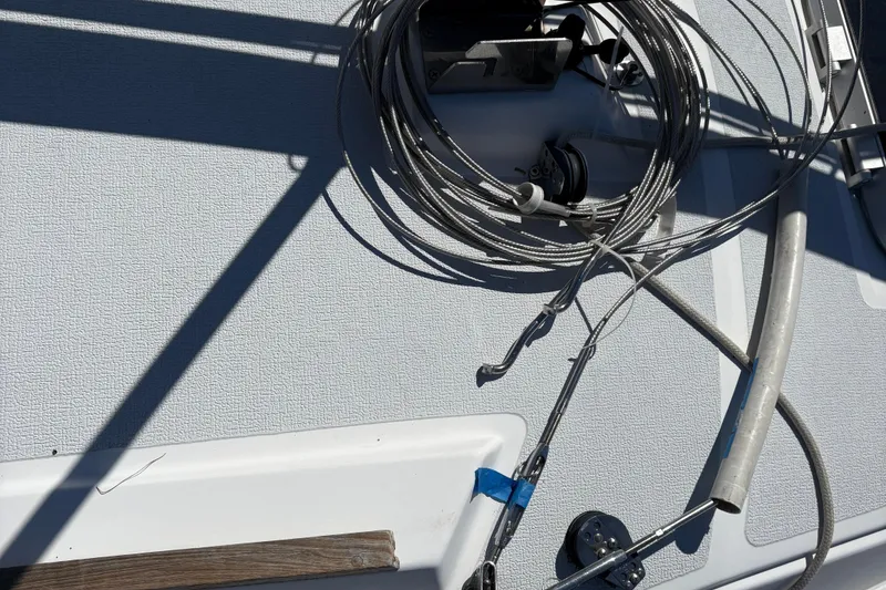 Slide: The Image of Deck of 2002 Precision 23 sailboat with coiled rigging cables and shadows. - 23