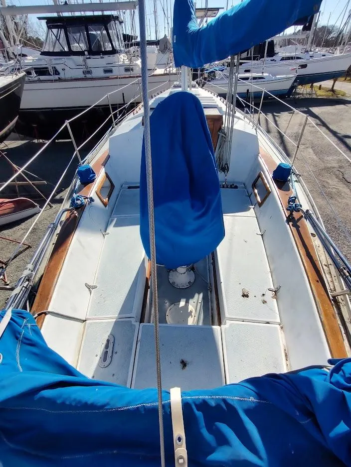 Slide: The Image of 1979 Endeavour 32 sailboat deck with blue covers and wooden accents. - 10
