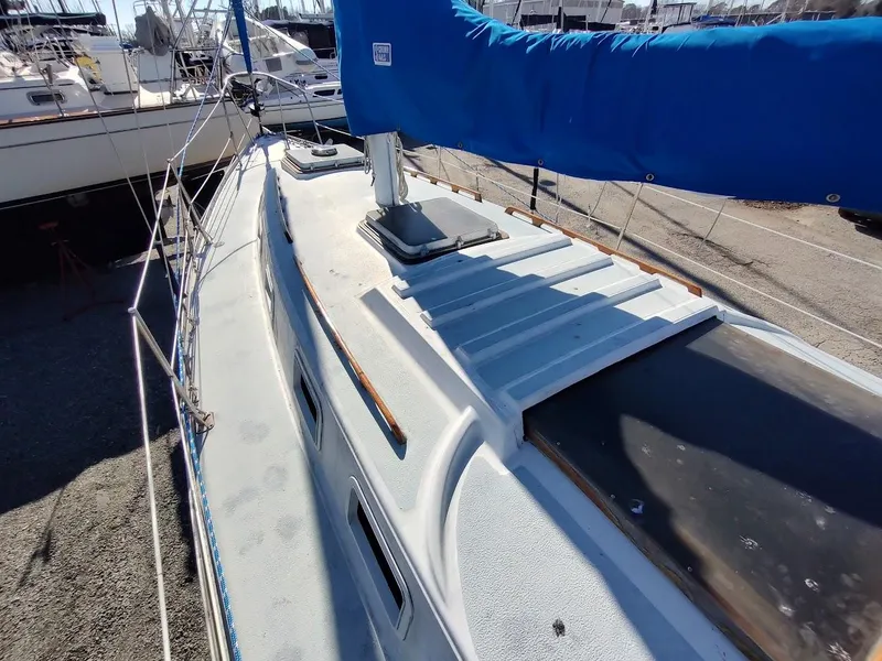 Slide: The Image of 1979 Endeavour 32 sailboat deck with blue sail cover, docked in a marina. - 11