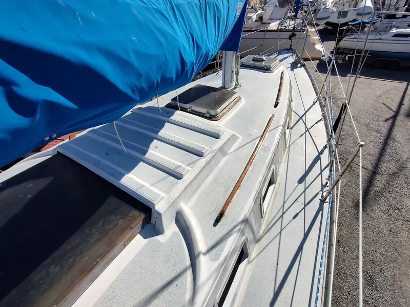 Slide: The Image of 1979 Endeavour 32 sailboat deck with blue sail cover, docked in marina. - 12