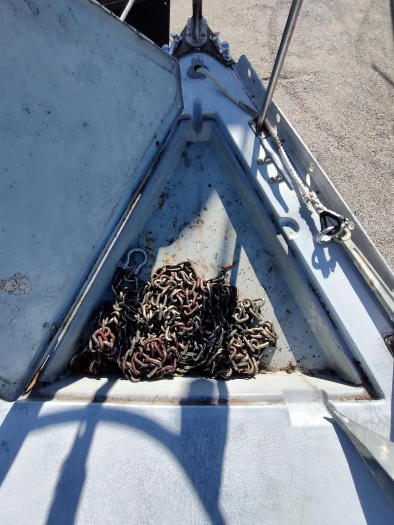 Slide: The Image of Anchor chain storage on 1979 Endeavour 32 sailboat, showing rusted chains and open hatch. - 14