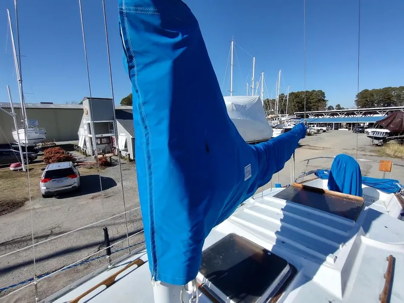 Slide: The Image of 1979 Endeavour 32 sailboat with blue sail cover in a marina setting. - 19
