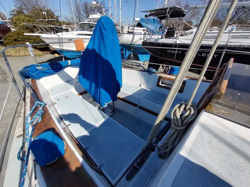 Slide: The Image of 1979 Endeavour 32 sailboat cockpit with blue covers, docked among other boats. - 22