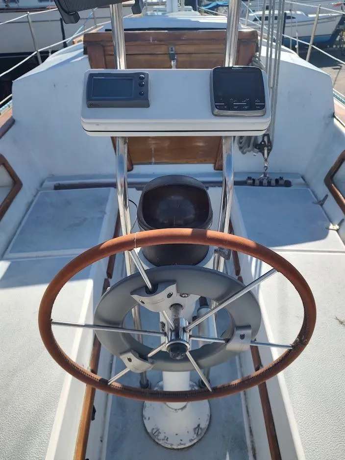 Slide: The Image of 1979 Endeavour 32 sailboat helm with wooden wheel and navigation instruments. - 24