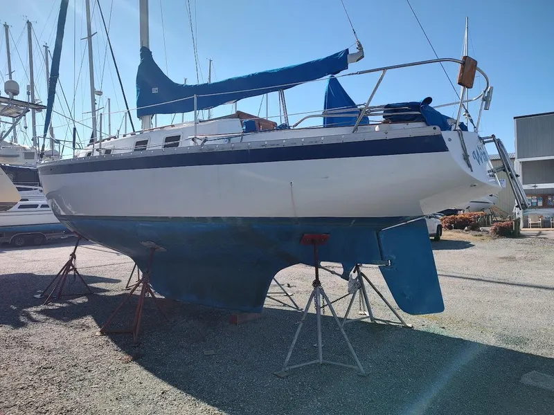 Slide: The Image of 1979 Endeavour 32 sailboat on stands in a boatyard under clear blue sky. - 4