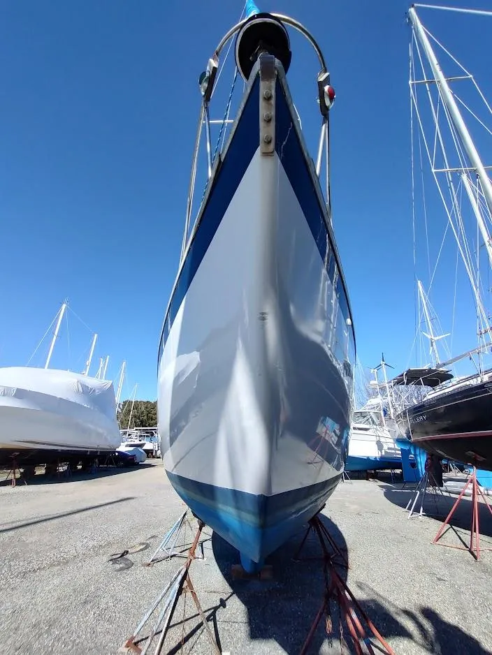 Slide: The Image of 1979 Endeavour 32 sailboat on stands in a boatyard under clear blue sky. - 6