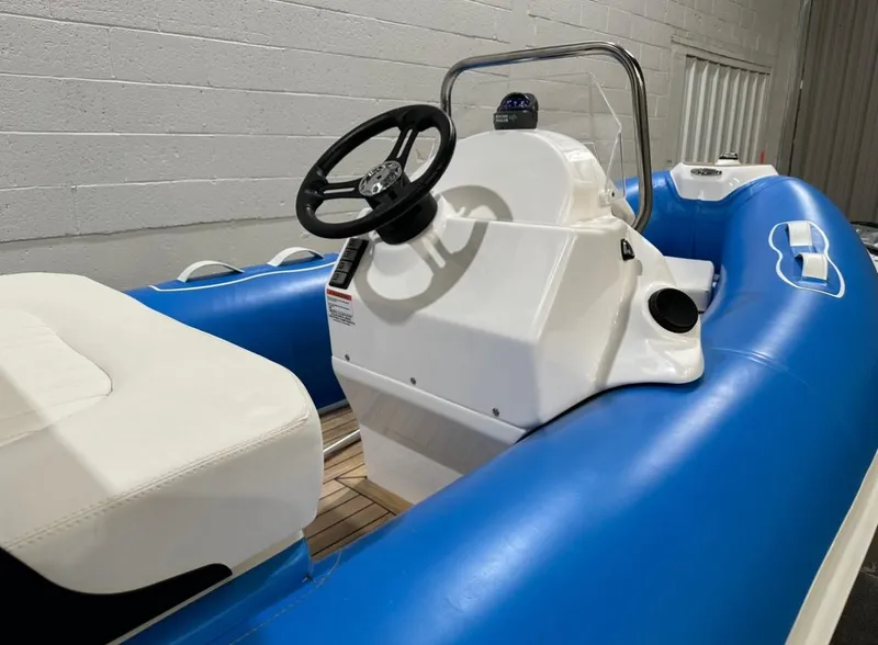 Slide: The Image of 2024 Apex A-12 Deluxe Tender with blue inflatable sides and white seating. - 12