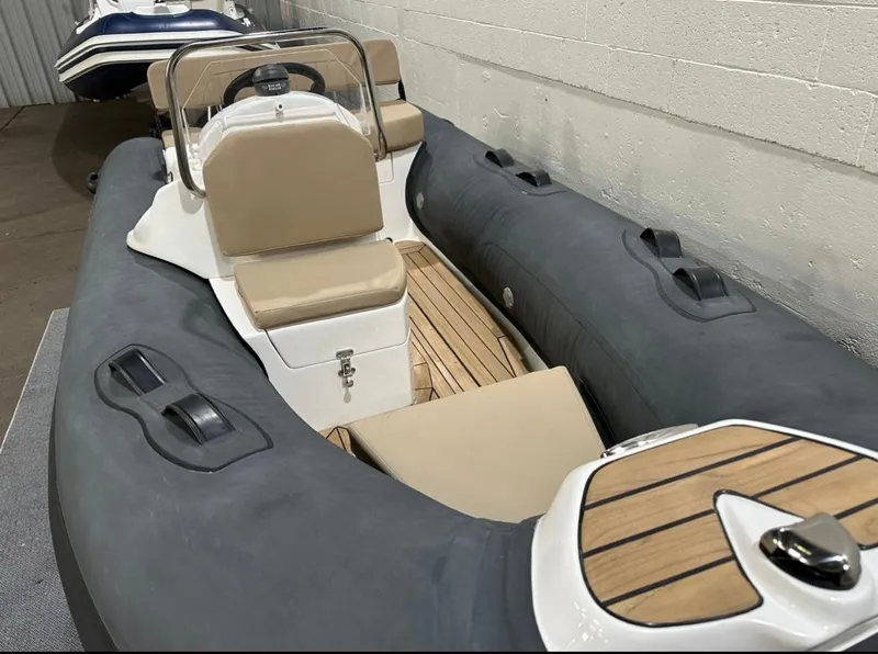 Slide: The Image of 2024 Apex A-12 Deluxe Tender with beige seating and wooden deck in a showroom. - 5