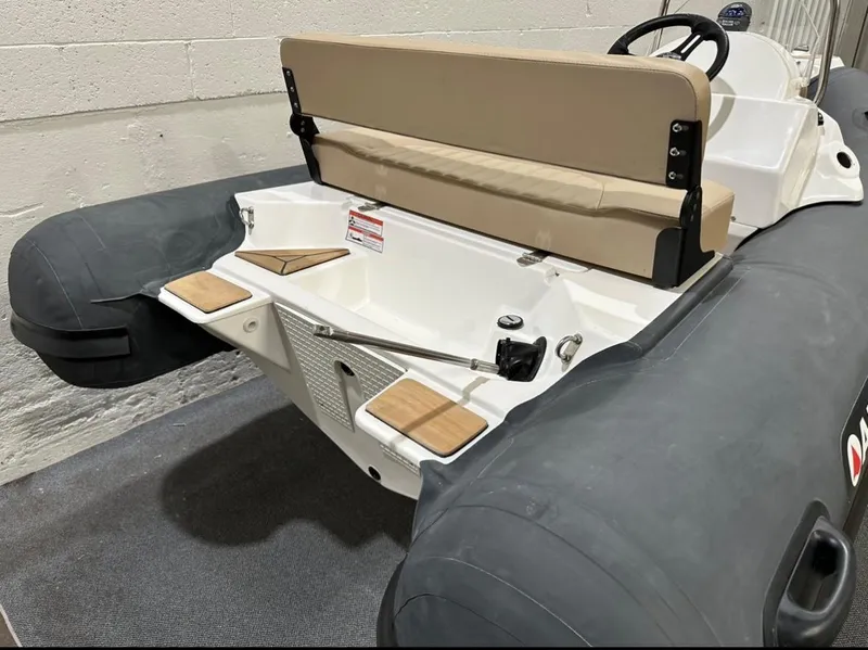 Slide: The Image of 2024 Apex A-12 Deluxe Tender with beige seating and black pontoons in a showroom. - 8