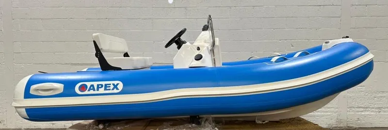 Slide: The Image of 2024 Apex A-12 Deluxe Tender, blue inflatable boat with steering console, side view. - 9