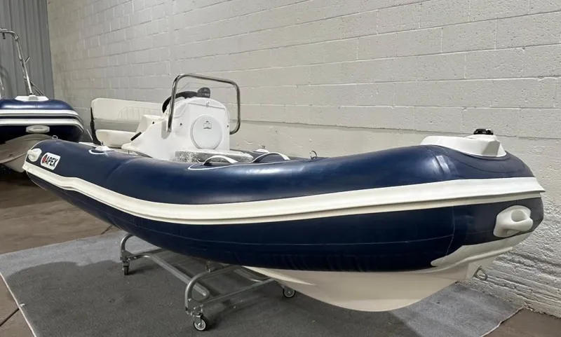 Slide: The Image of 2024 Apex A-13 Deluxe Tender, blue and white inflatable boat in showroom. - 3
