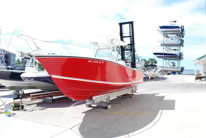 Slide: The Image of 1996 Regulator 26 Classic boat with a vibrant red hull on a dock. - 13