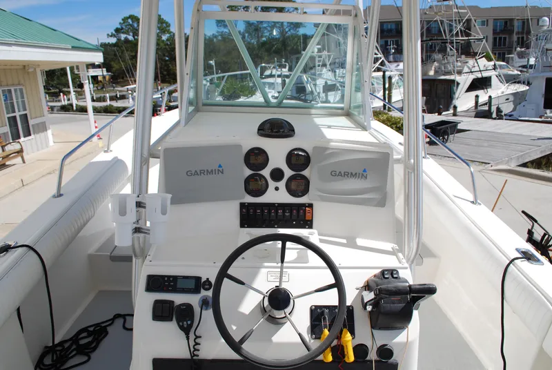 Slide: The Image of 1996 Regulator 26 Classic boat helm with Garmin electronics at a marina. - 19