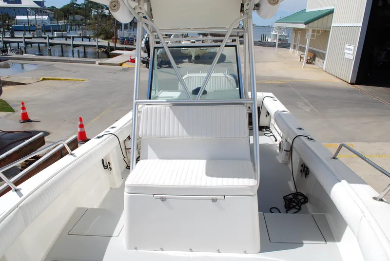 Slide: The Image of 1996 Regulator 26 Classic boat interior with white seating and dockside view. - 25