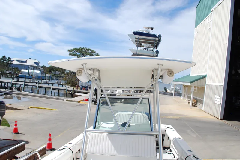 Slide: The Image of 1996 Regulator 26 Classic boat docked near a marina with clear skies. - 26